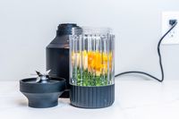 Fruit and vegetables inside cup with open lid of the Beast Mega 1200 Blender
