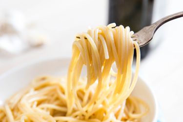 Closeup of pasta aglio e olio twirled on a fork.