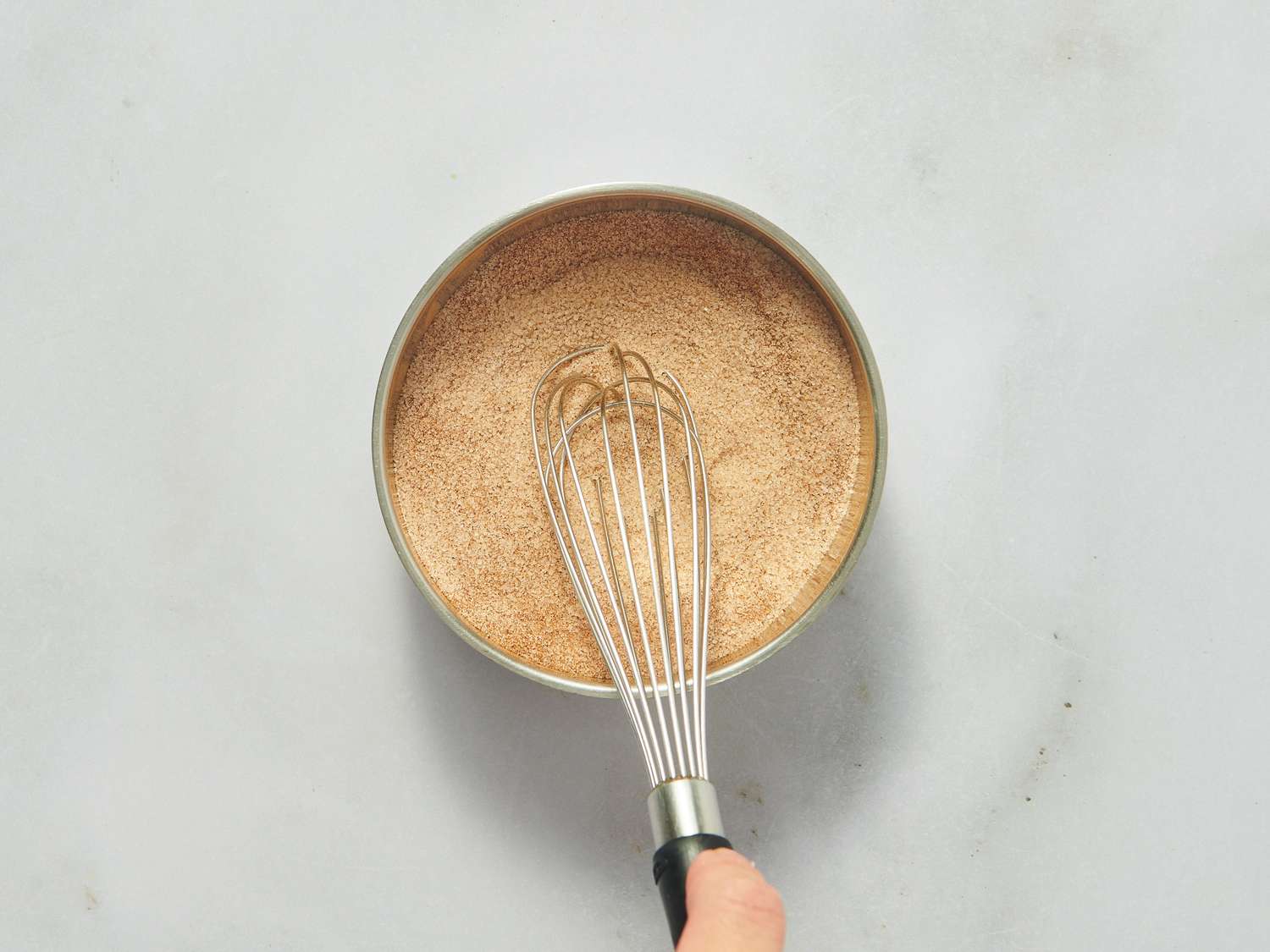Whisking cinnamon and sugar together in a bowl.