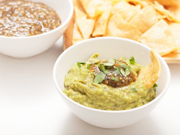 Guacamole with roasted tomatillos, served with chips and another salsa.
