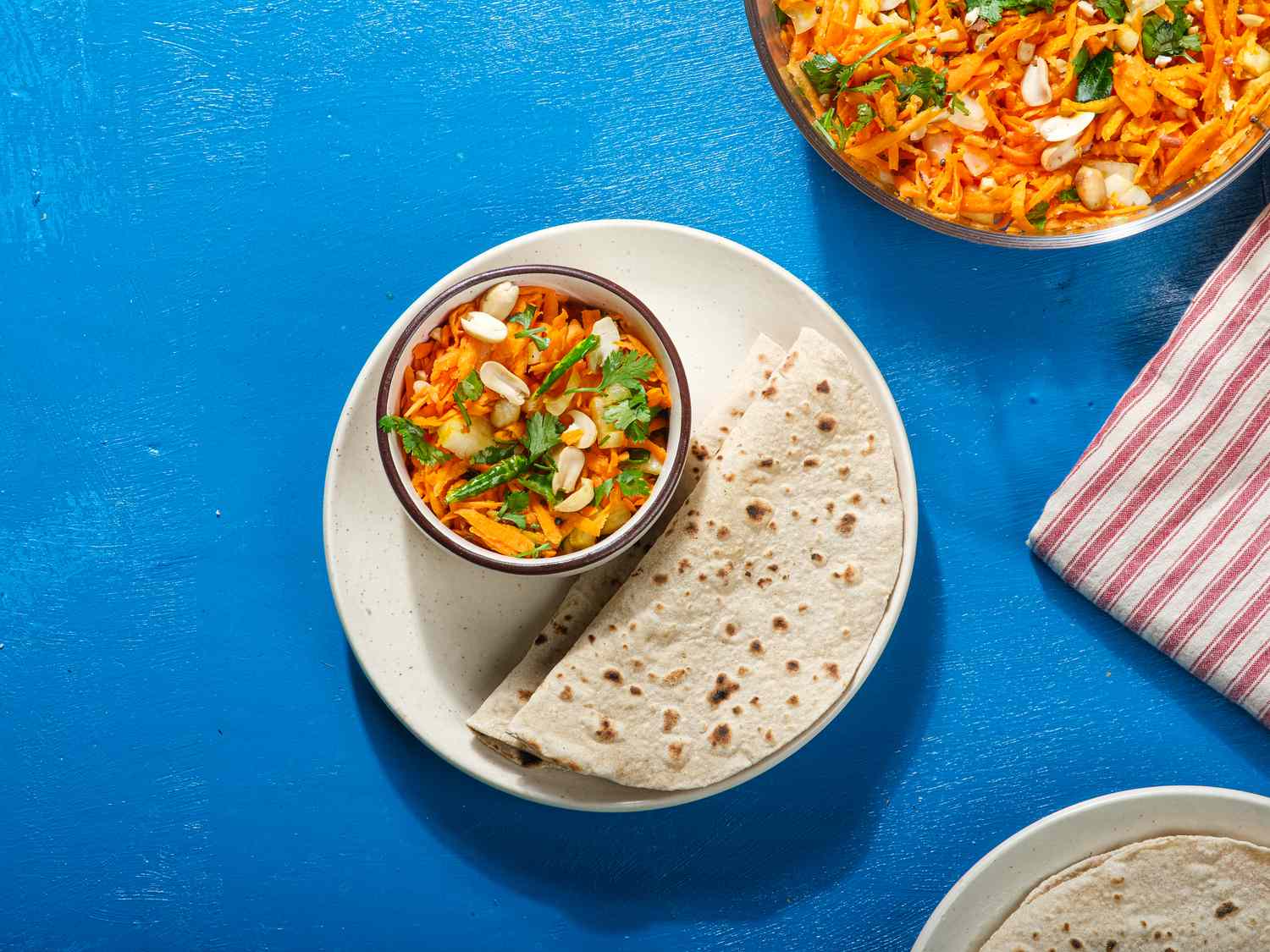 Overhead view of Gajarachi Koshimbir, served in a bowl with flatbreads nearby.