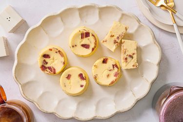 Overhead off egg bites on a scalloped platter with coffee, smaller plates and gold forks to the side