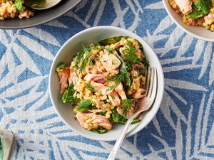 Couscous salad with salmon and mustard-dill dressing served inside a dish and garnished with dill
