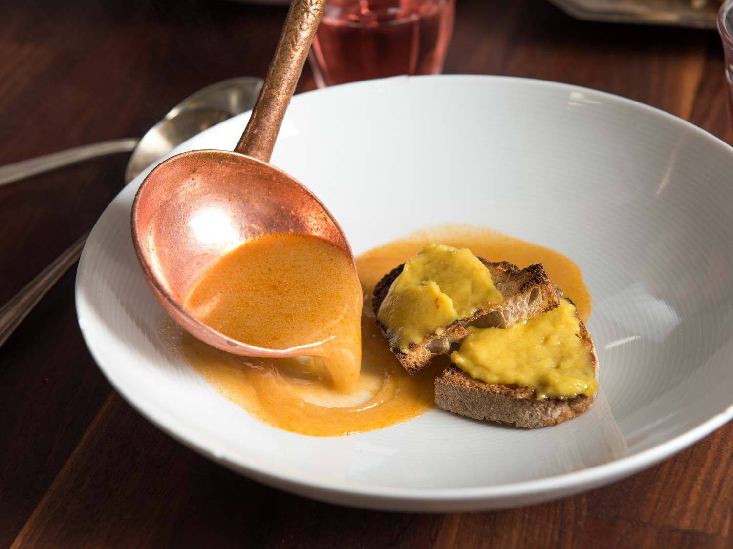 Ladling the soup into a bowl for bouillabaisse.