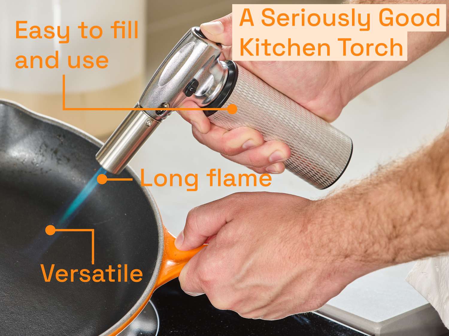 a kitchen torch being used to heat the center of a skillet