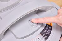 A person flips a switch on the lid of the Instant Pot Duo Plus 8 Quart Multi-Use Pressure Cooker