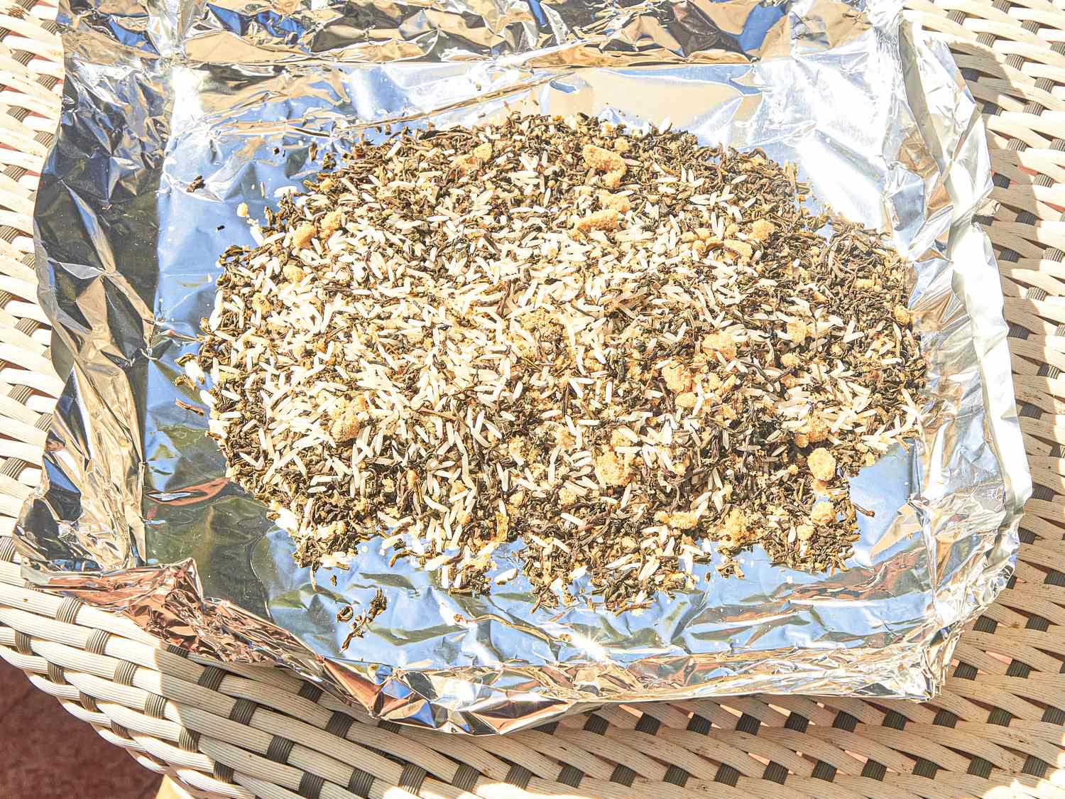 A foillined tray with a mixture of tea leaves and other ingredients outdoors