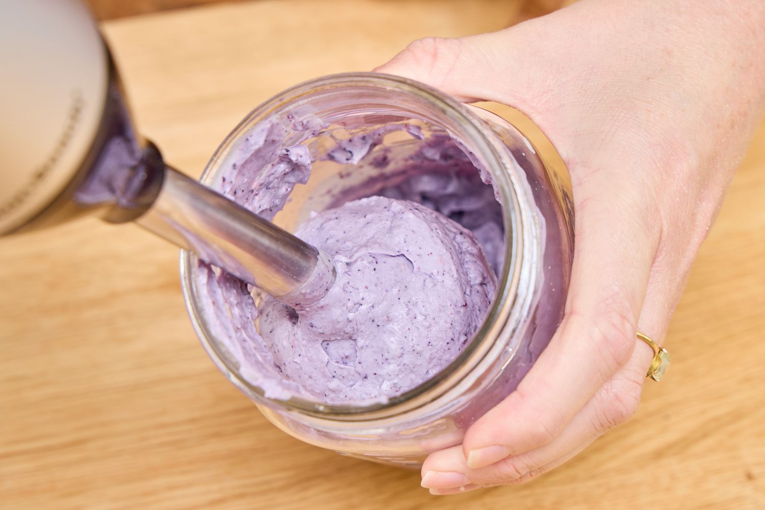 A person makes a smoothie using the Hamilton Beach 2-Speed Hand Blender