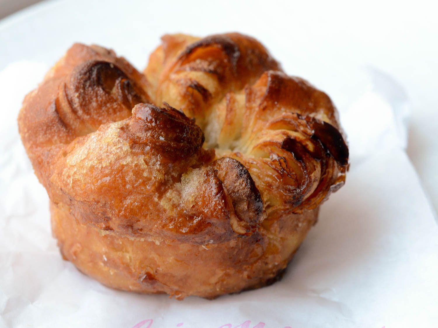 Kouign amann on top of white paper bag.