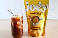 A glass of iced coffee next to Joe'y coffee alternative packaging