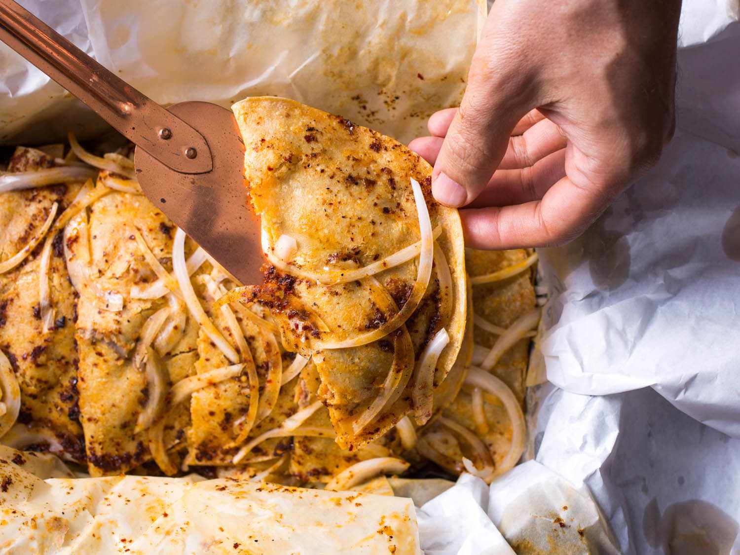 Lifting an assembled taco out of its serving container