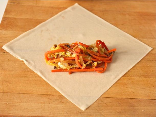 The egg roll filling is spooned in the lower center of the wrapper.