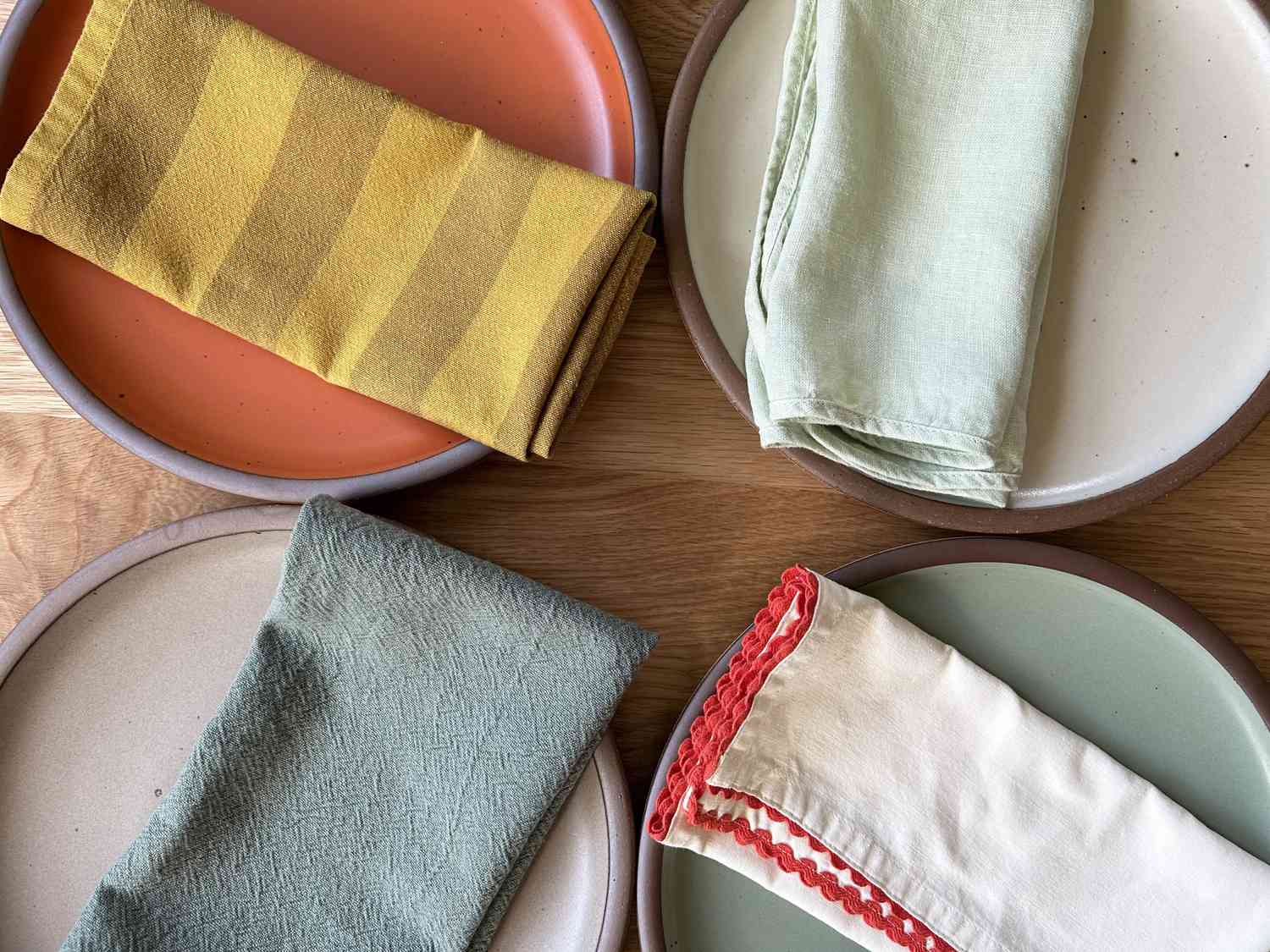 Four cloth napkins on dining plates