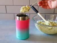 a person filling thermos with egg salad