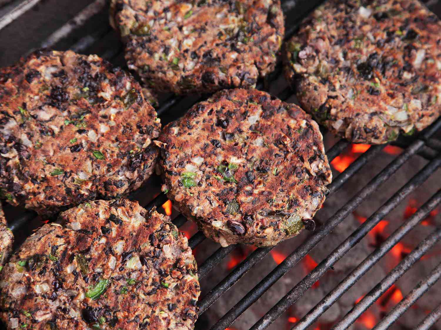 Black bean burgers grilling over charcoal