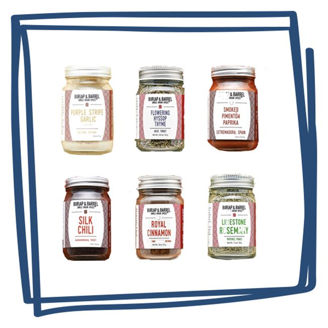 A collection of six spice jars from Burlap Barrel labeled with garlic pepper paprika chili cinnamon and rosemary varieties