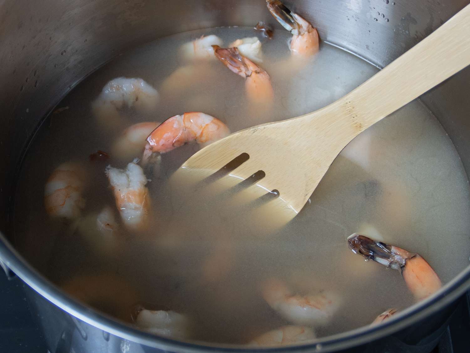 Shrimp being cooked in stock.