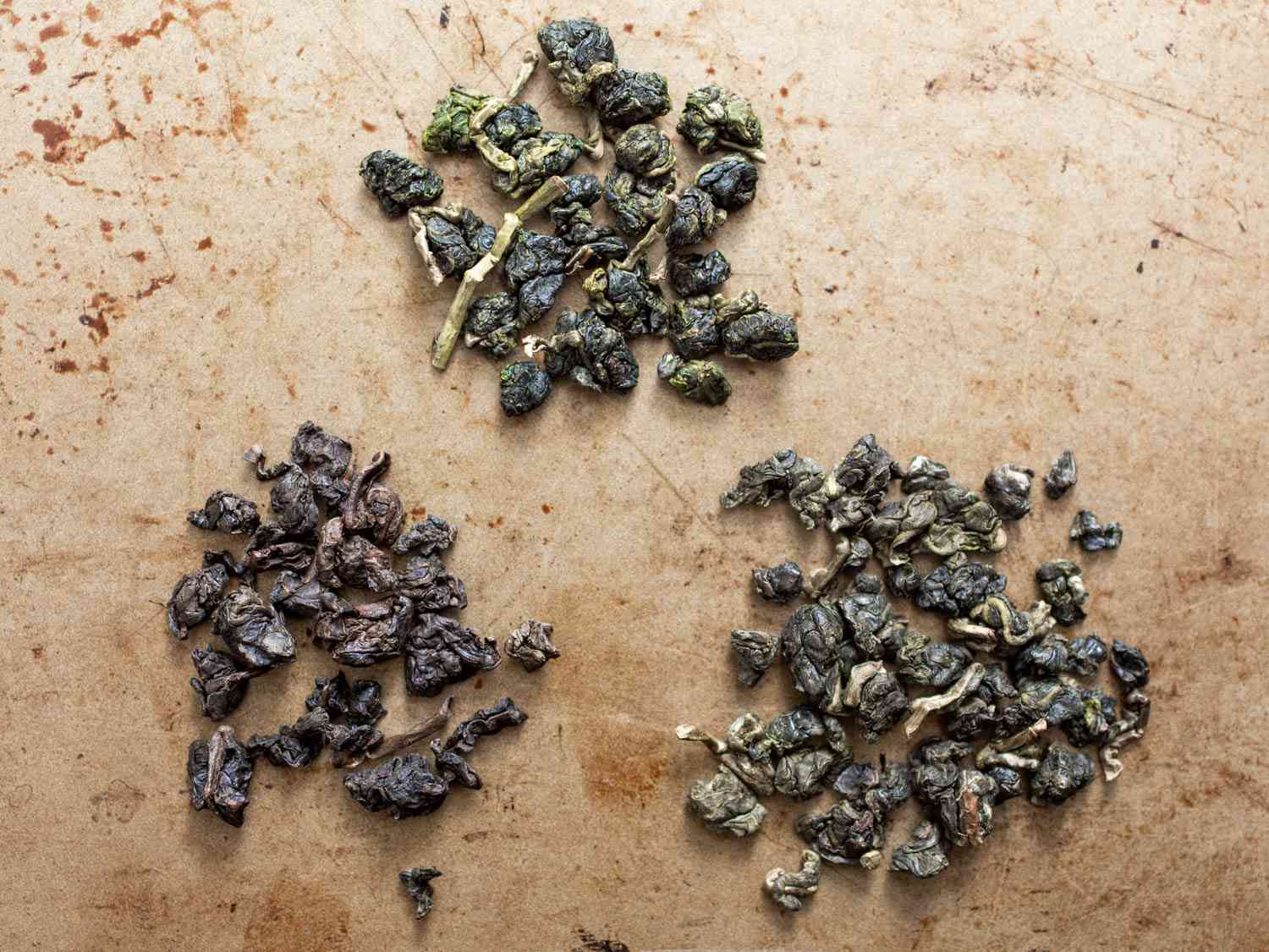 Three small clusters of dried oolong tea leaves