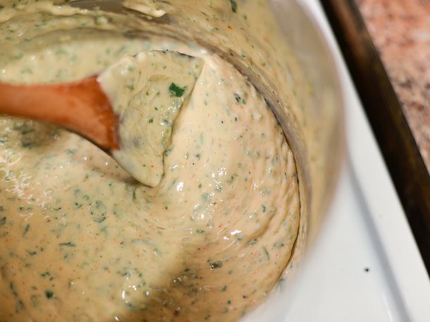 The queso is stirred in a pot with a wooden spoon.