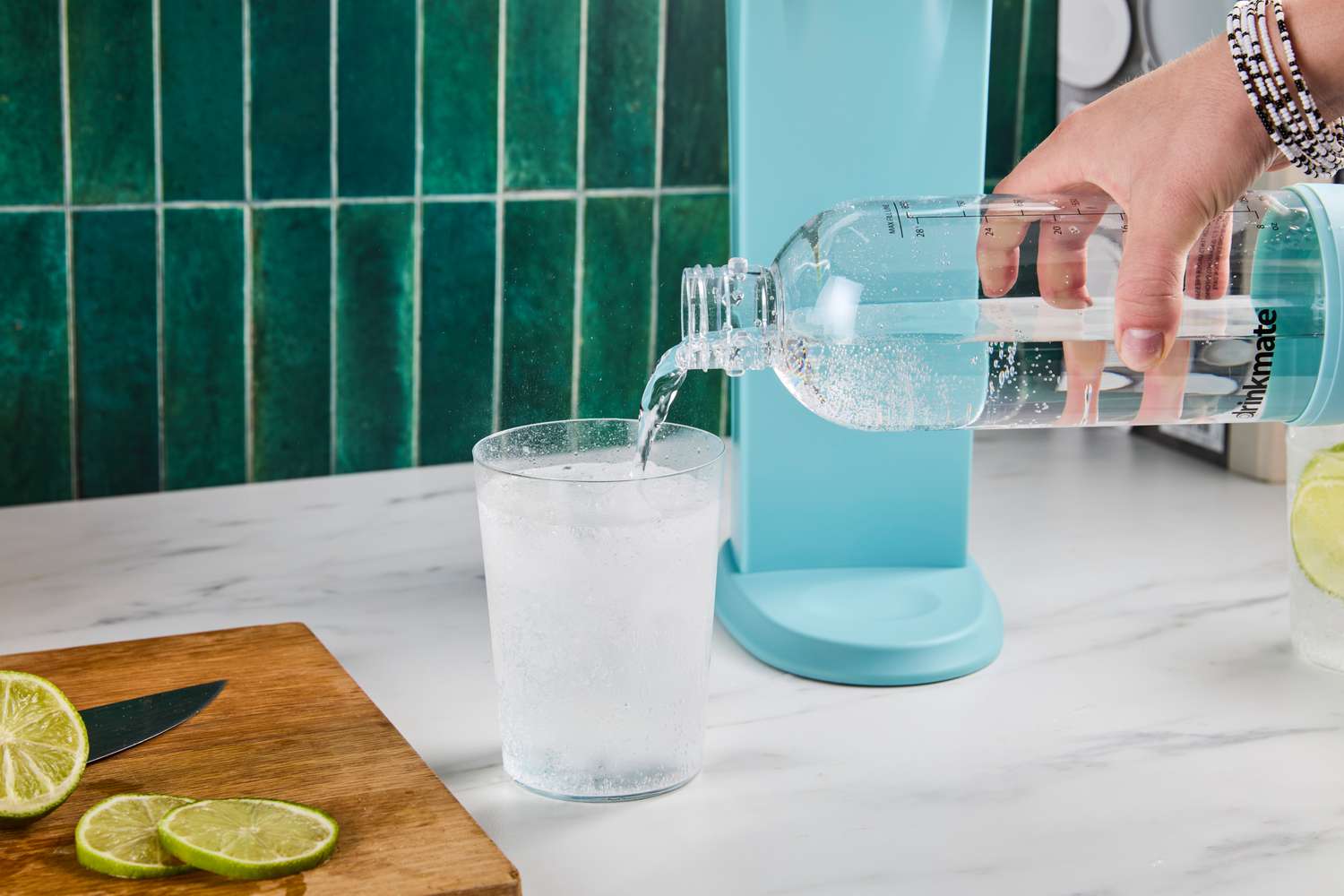 Pouring sparkling water from the Drinkmate bottle into a glass.
