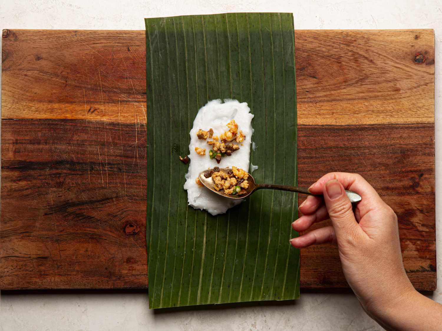 Scattering filling over rice mix on banana leaf