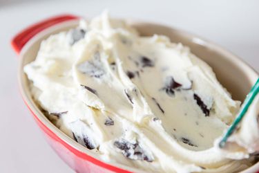 A ceramic pie plate full of stracciatella gelato, ready to serve.