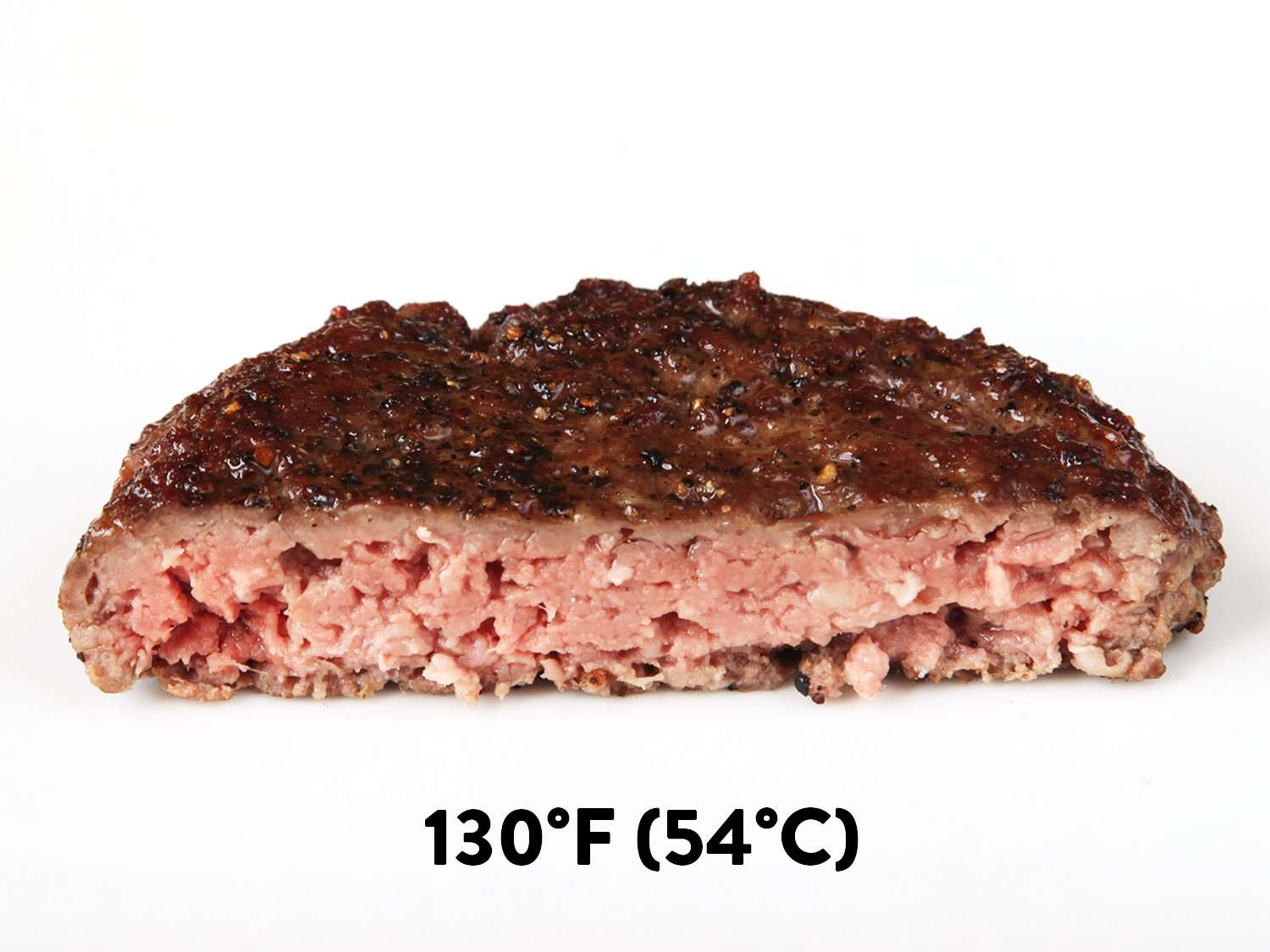 A sous vide hamburger cooked to 130F (medium) cut in half to reveal pink center.