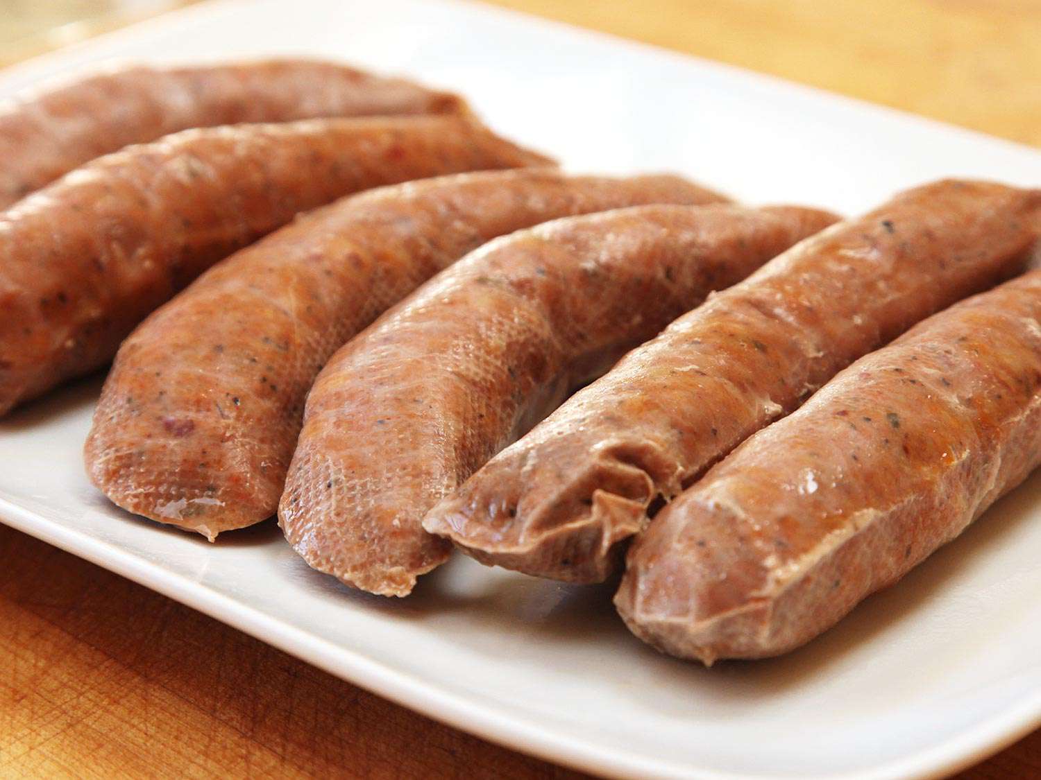 A platter of vacuum-sealed sausages that were cooked sous vide. The vacuum flattened them slightly.