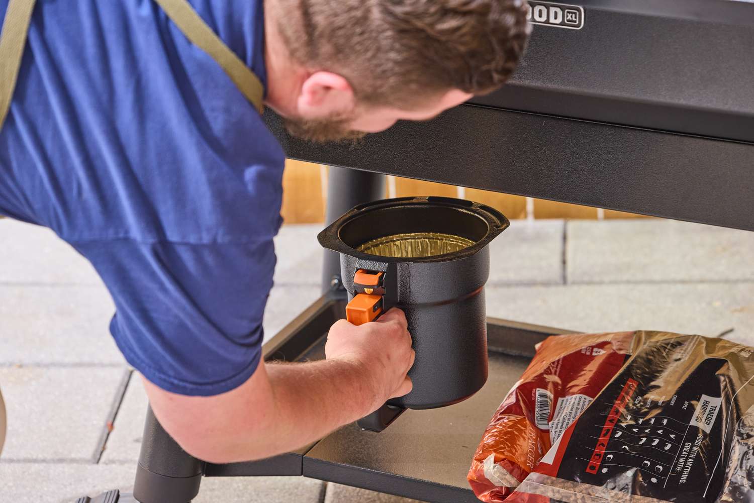 A person adds the grease tray into the Traeger Ironwood XL