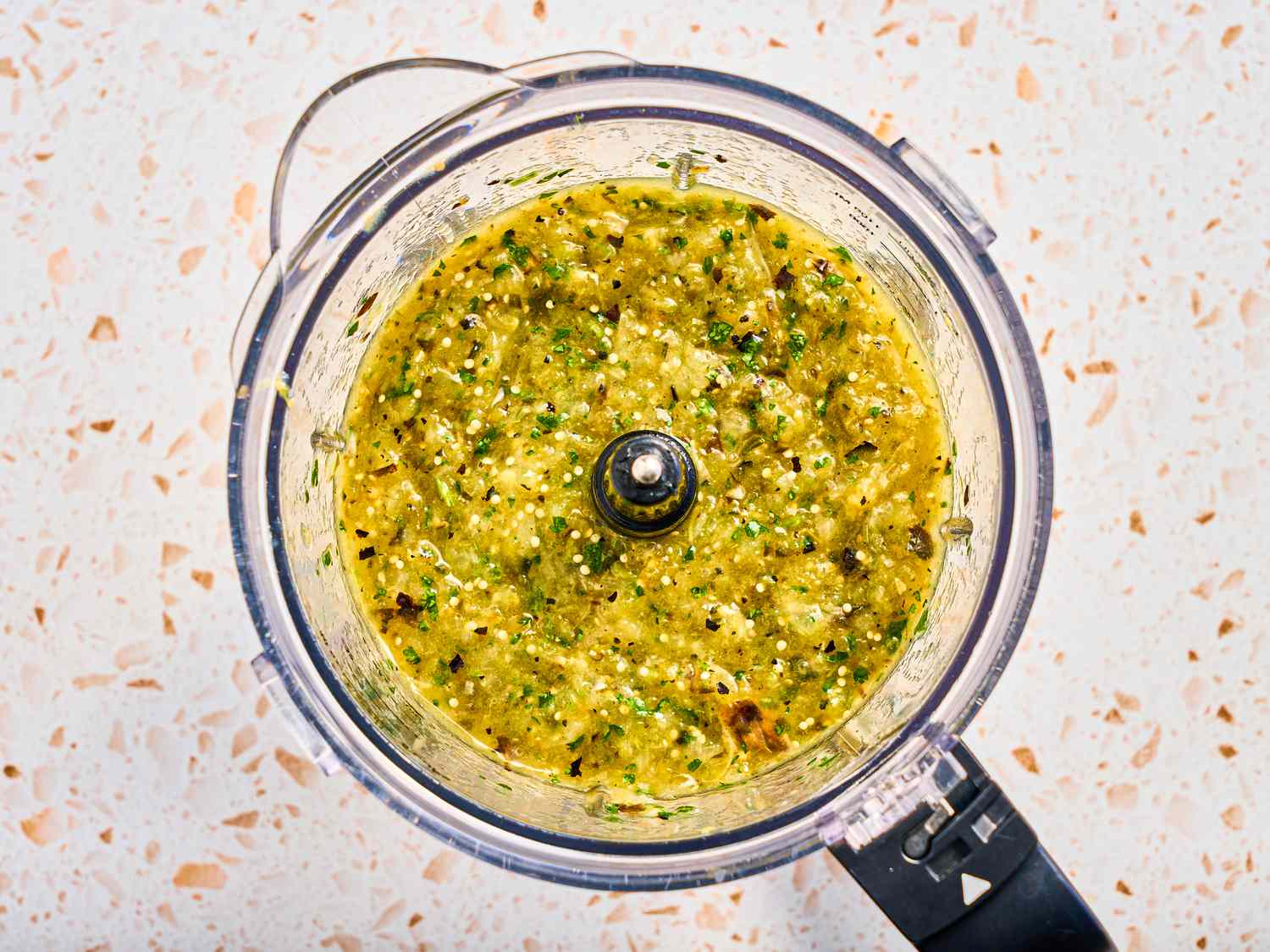 chilies and cilantro blended together in a food processor