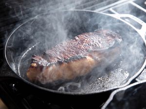 A peanut butter sous vide steak searing in a cast iron skillet. 