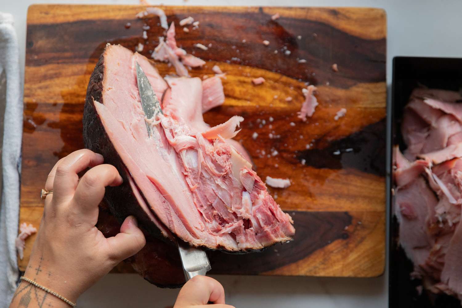 A person slicing meat using the Wusthof Classic Carving Knife