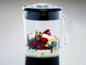 Blender jar containing fruits and yogurt
