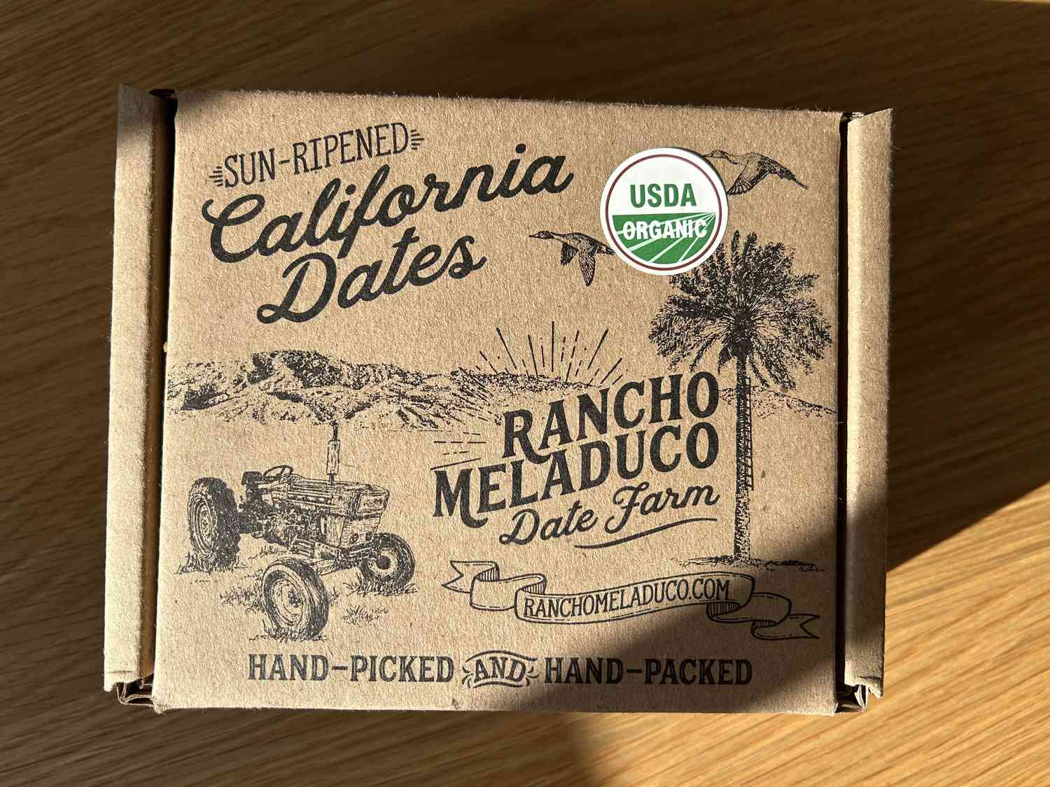 A box of dates on a wooden table.