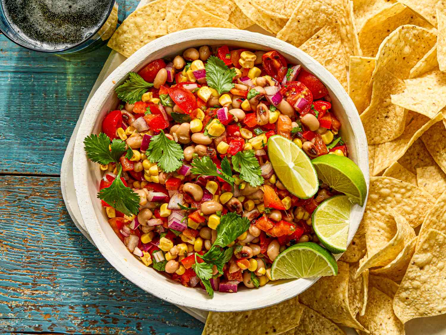 A bowl of cowboy caviar surrounded by tortilla chips