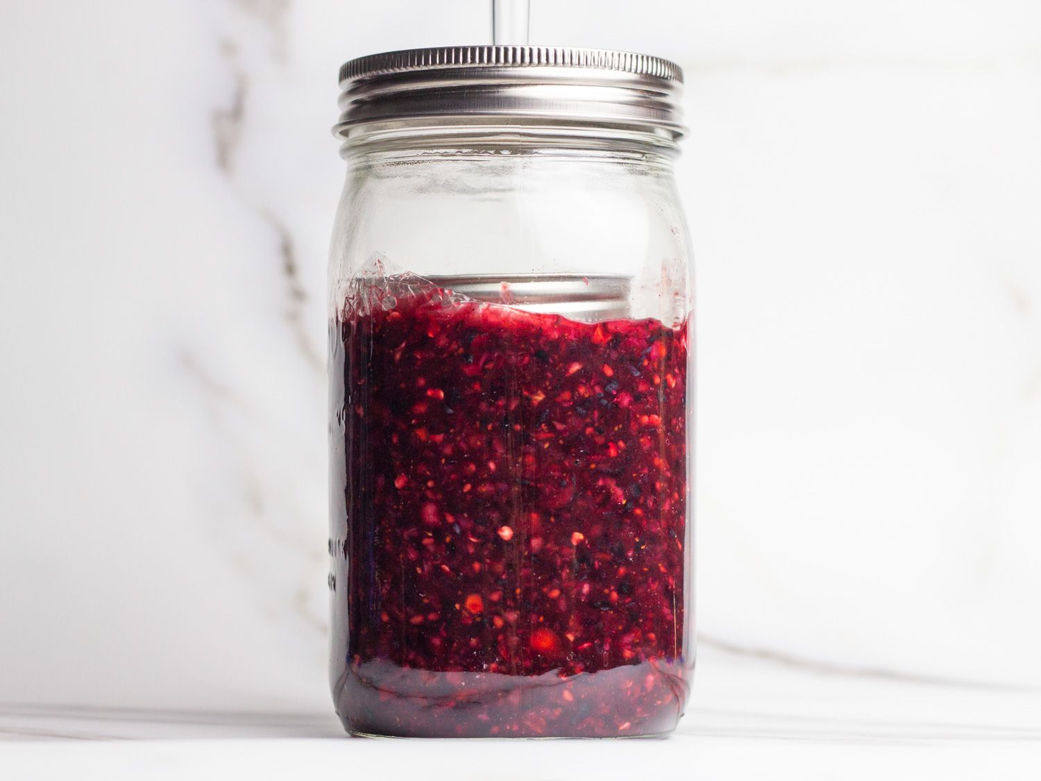 Profile view of a mason jar with the fermenting pepper-berry mash.