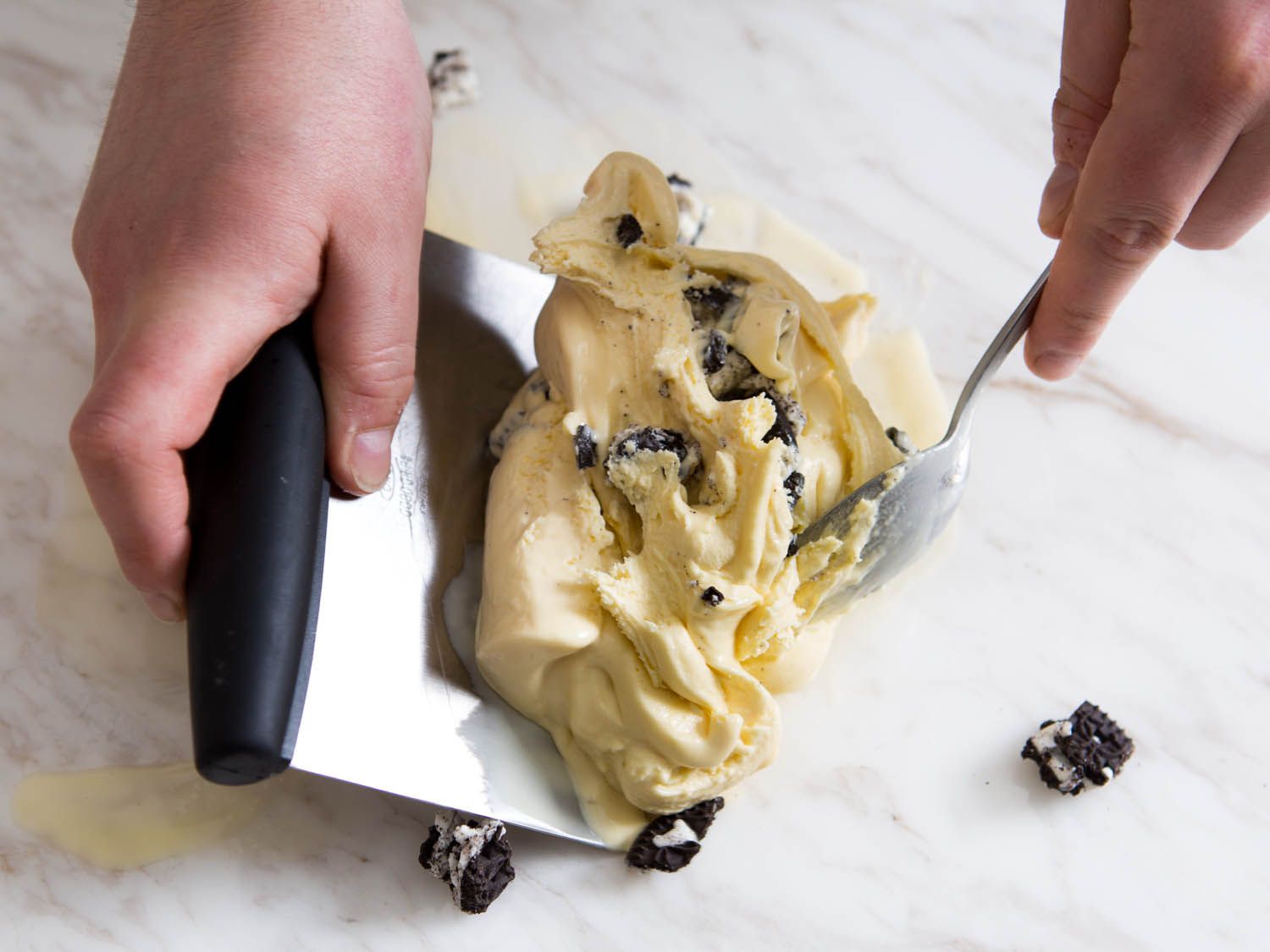 Shaping a slab of chewy New England-style ice cream with a bench scraper and a spoon.