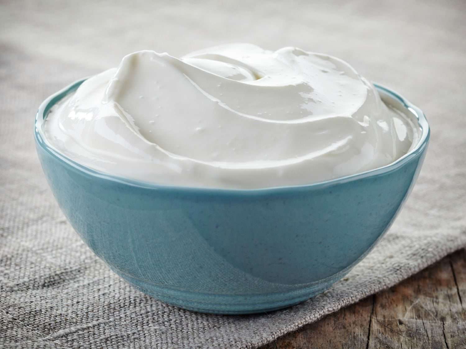 A bowl of sour cream on a table.