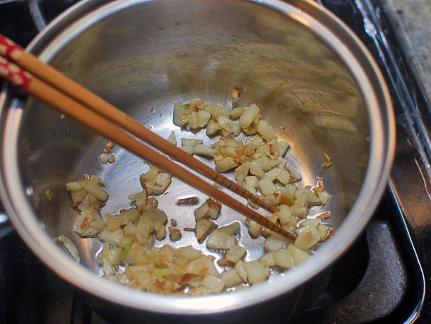Sautéing large chunks of garlic for a braised spinach and choy dish.