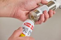 a person filling the rosle torch with butane