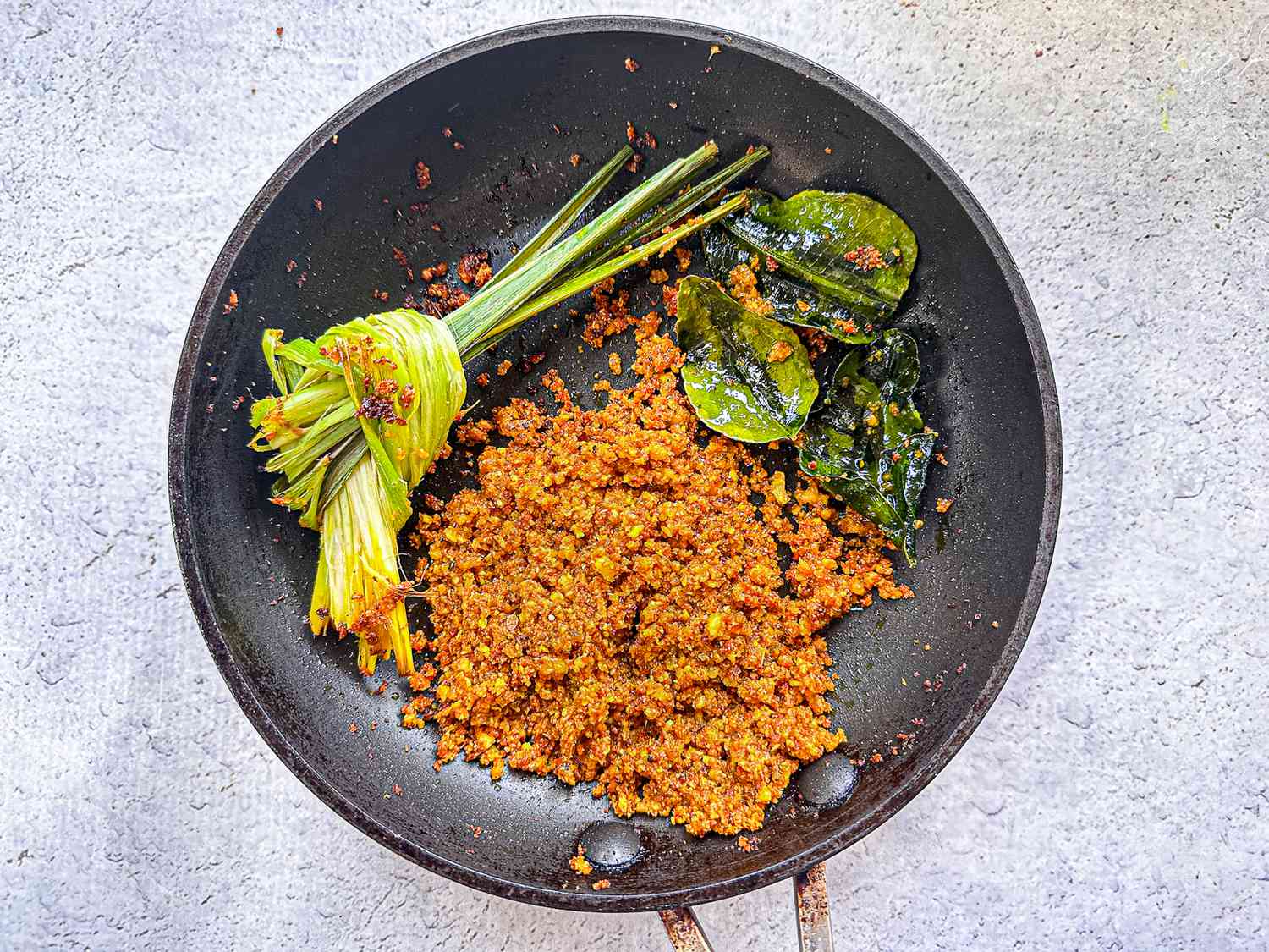 Spice paste, lemongrass and lime leaves fried in a skillet, after about 1 minute, when slightly darkened 