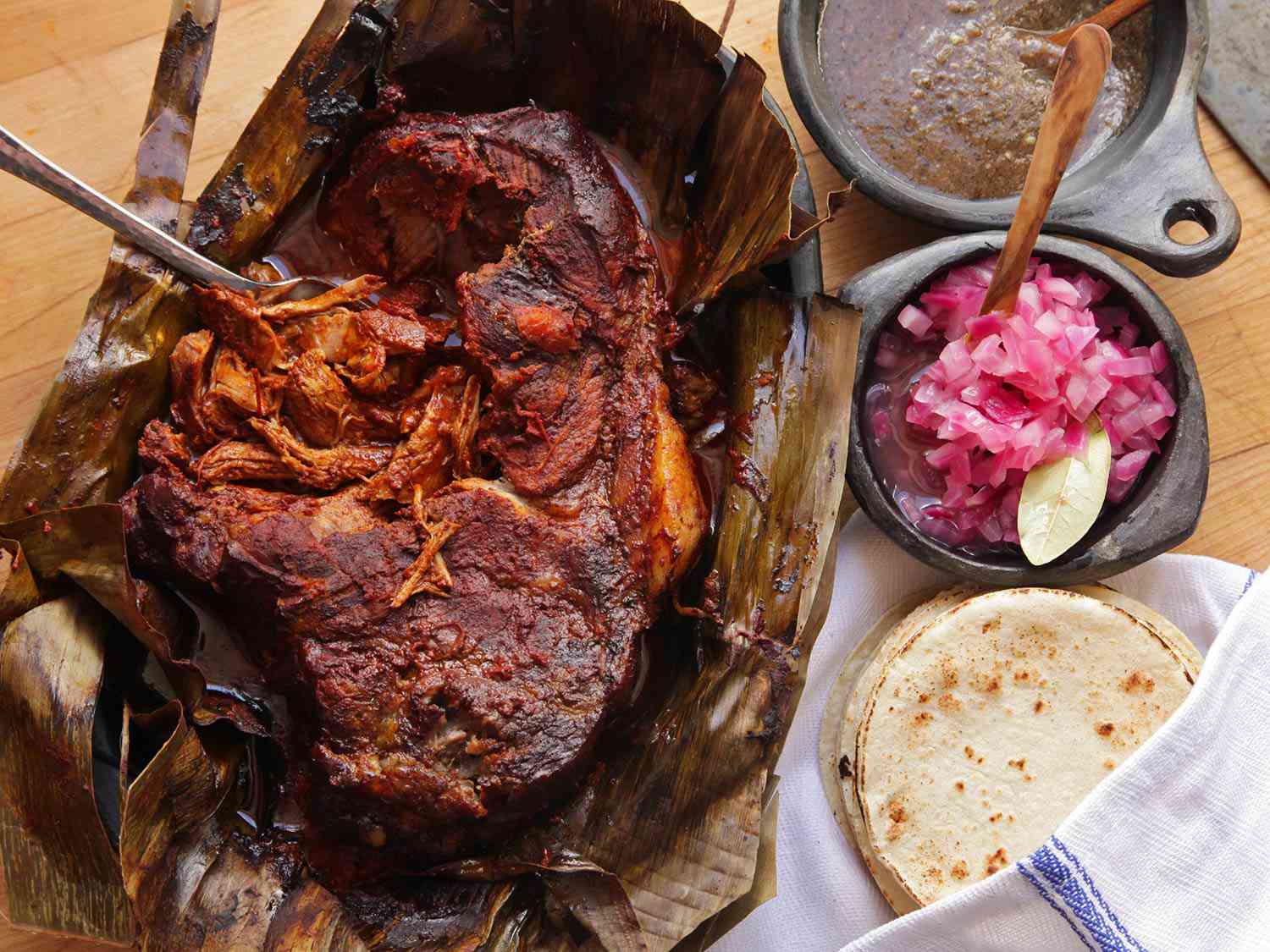 Finished cochinita pibil, served with pickled onions and habanero hot sauce.