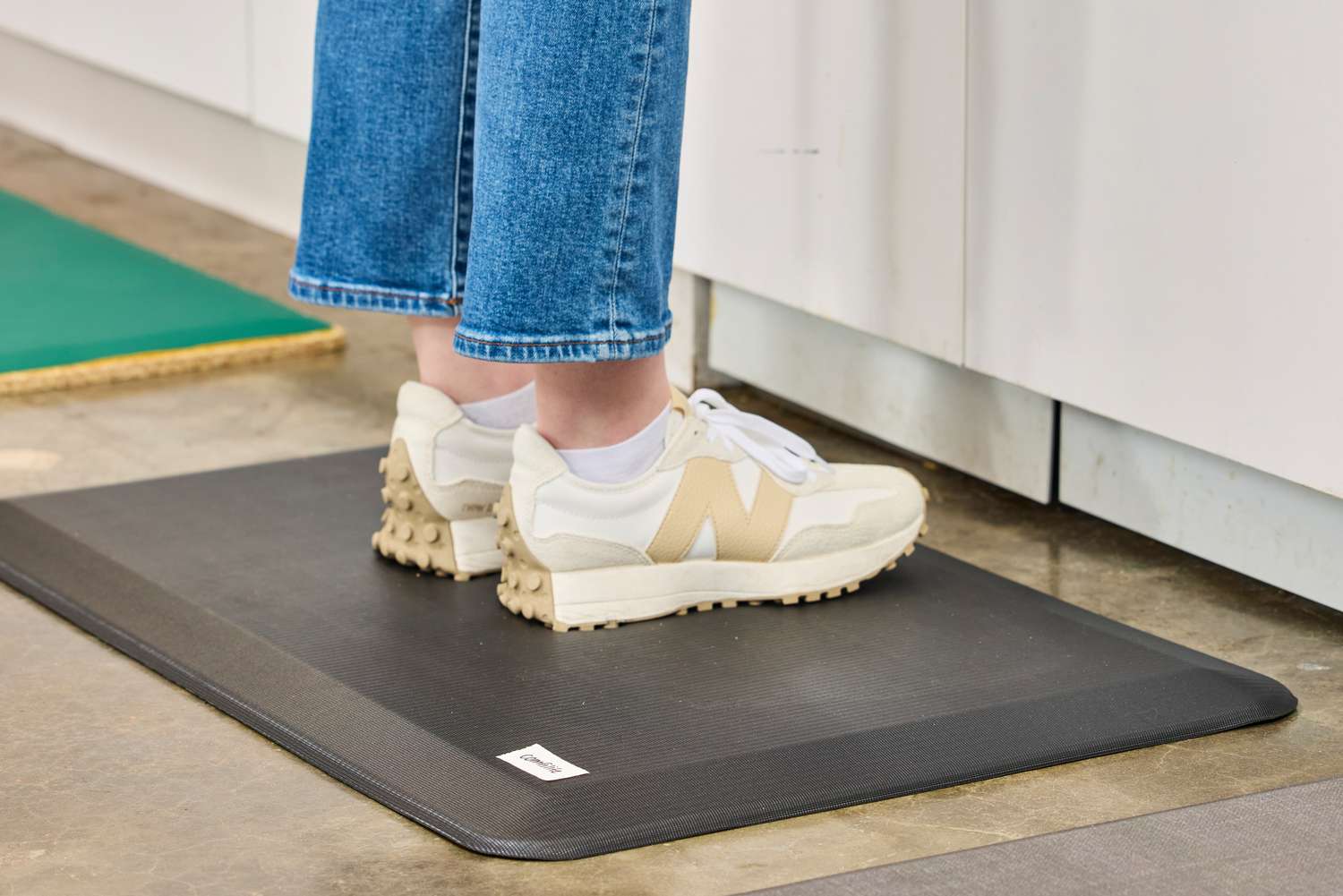 A person stands on the ComfiLife Anti-Fatigue Floor Mat