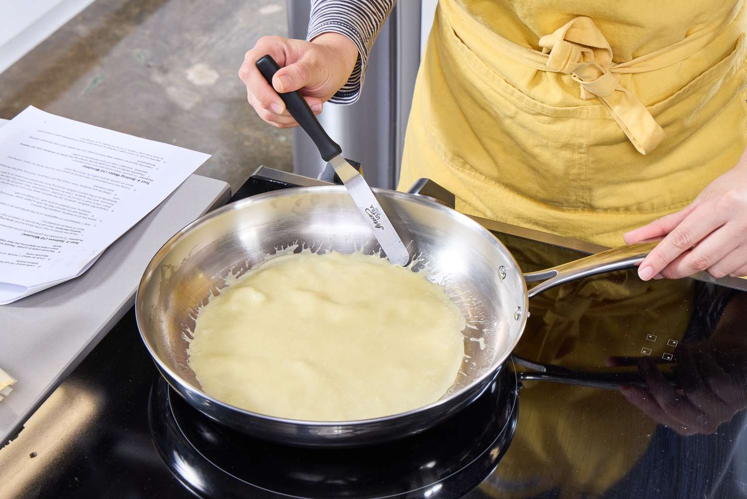 A person makes a crepe in the Tramontina 12-Inch Stainless Steel Skillet
