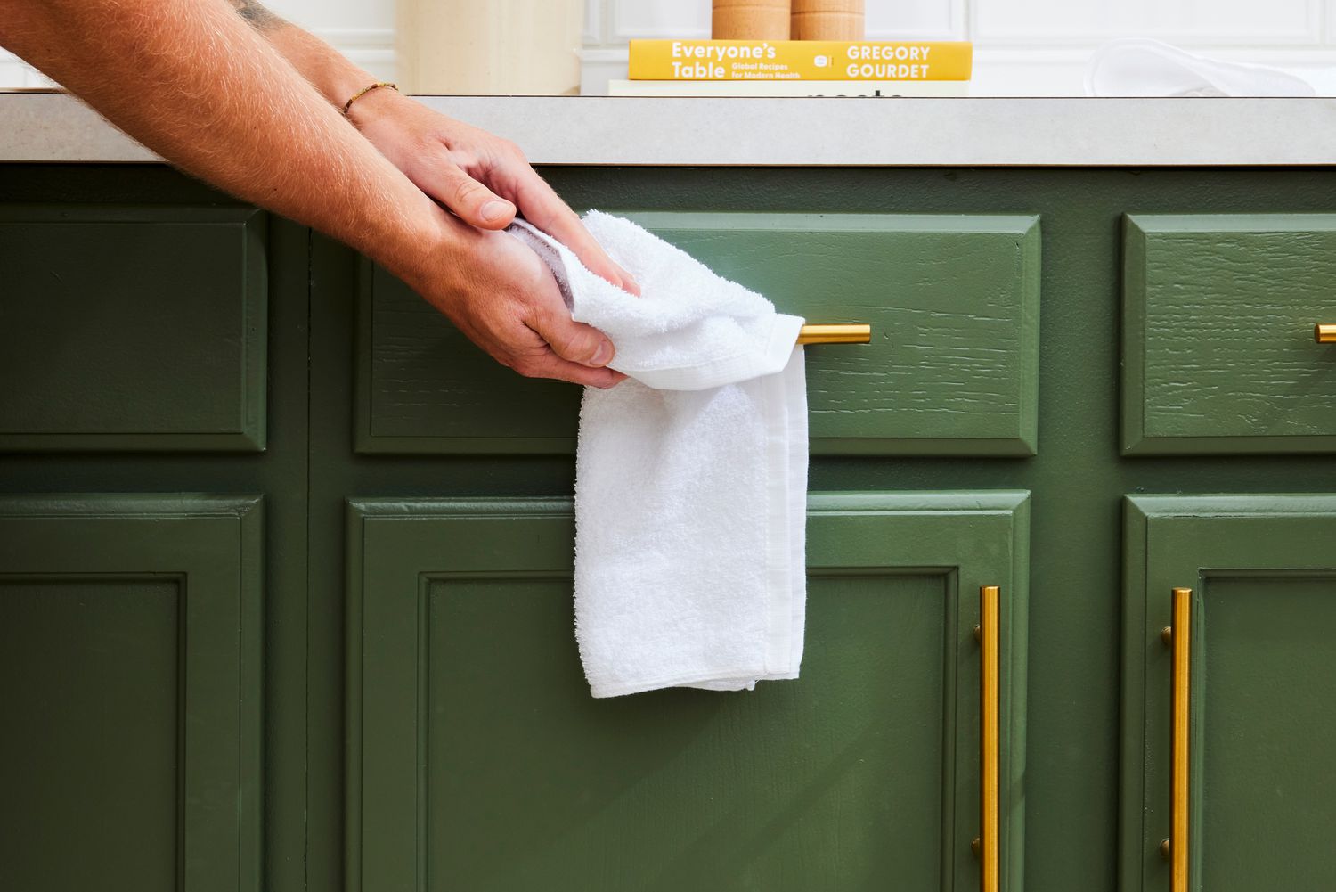 A person drying their hands on a white bar mop.
