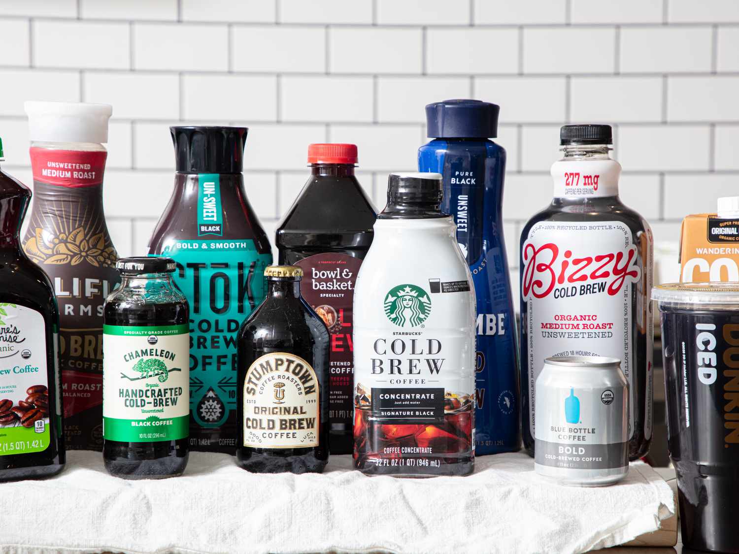 A variety of bottled cold brew coffee products displayed on a surface, arranged in a neat layout