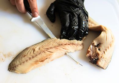 A person using the Wüsthof Classic Fish Fillet Knife to cut a fish