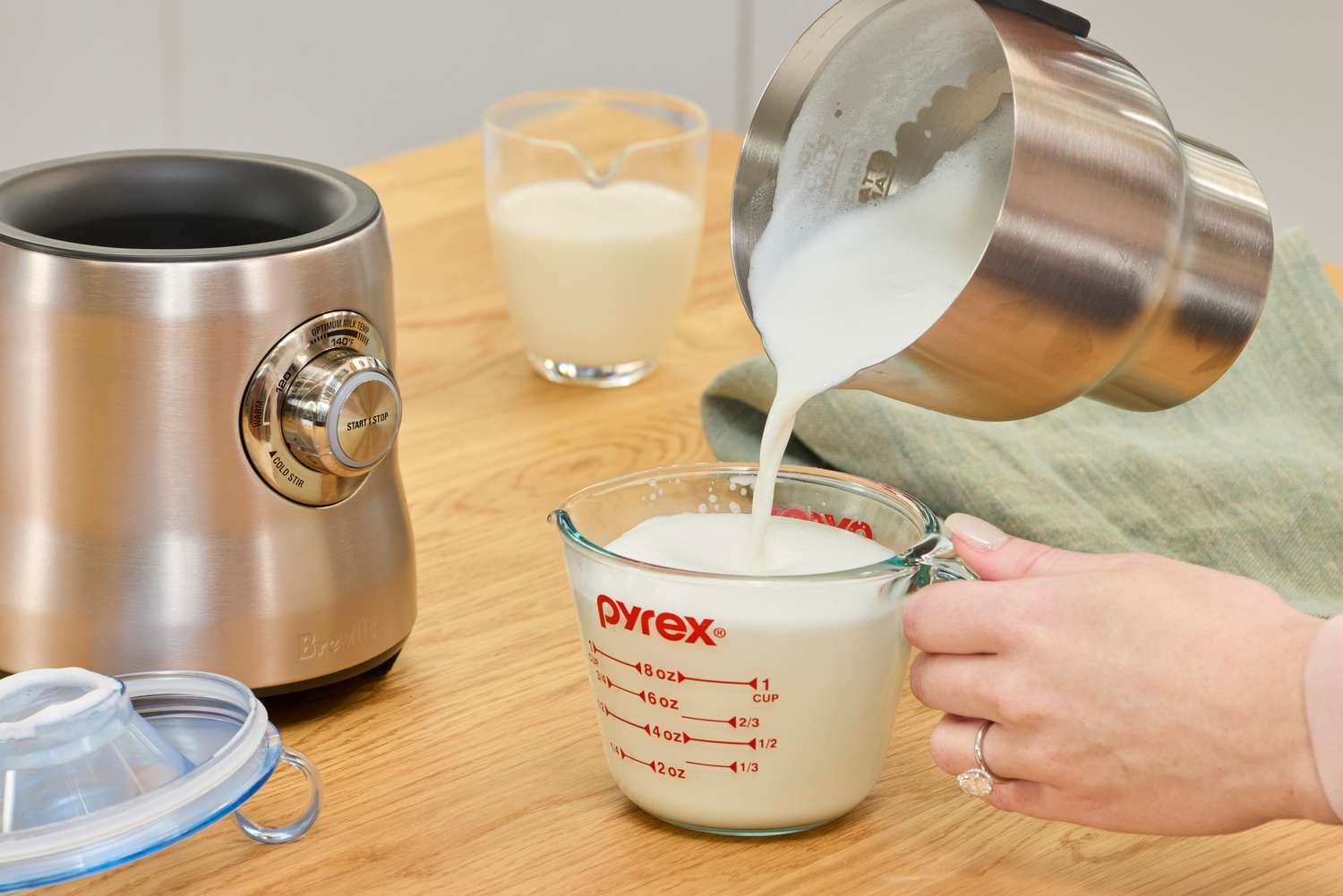 Pouring milk from the Breville's pitcher into a measuring cup.