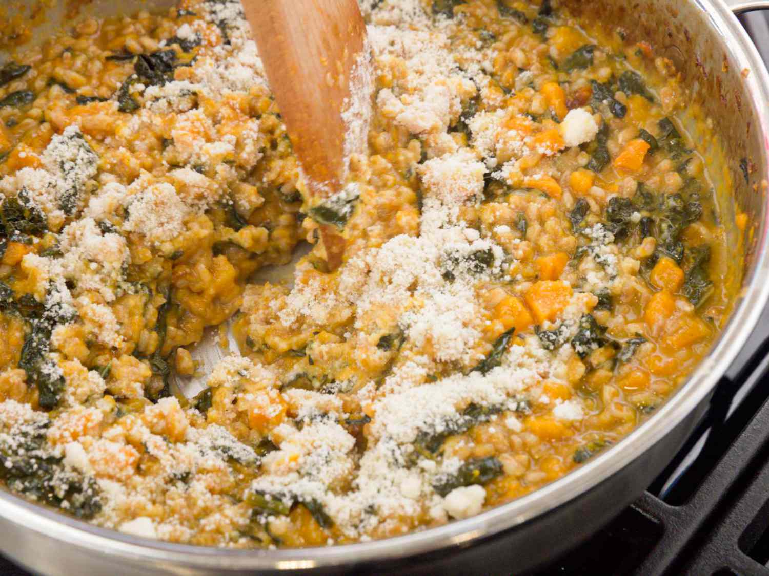 mixing cheese into farrotto on skillet 