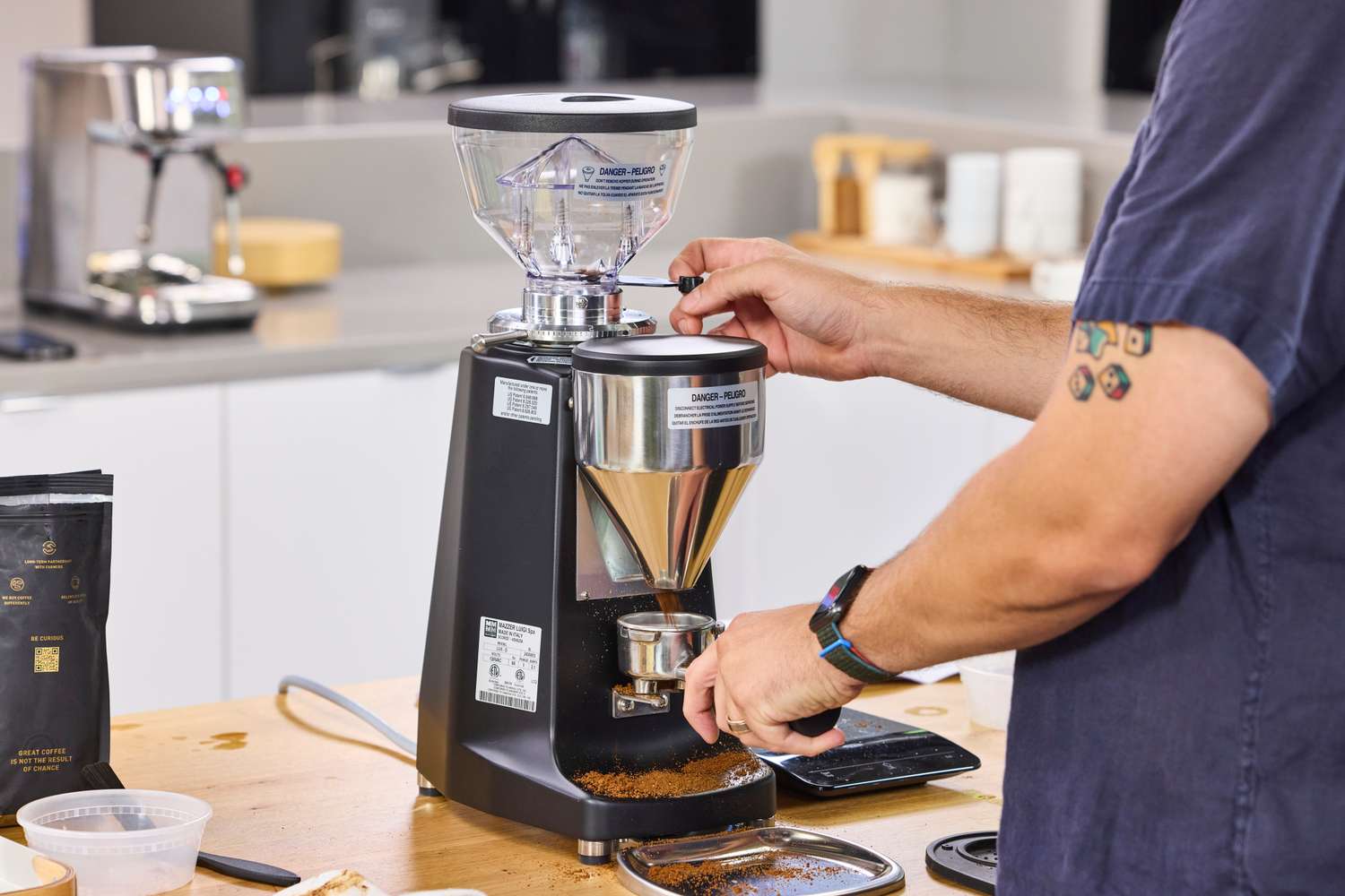 A person uses the Mazzer La Marzocco Lux D Coffee Grinder